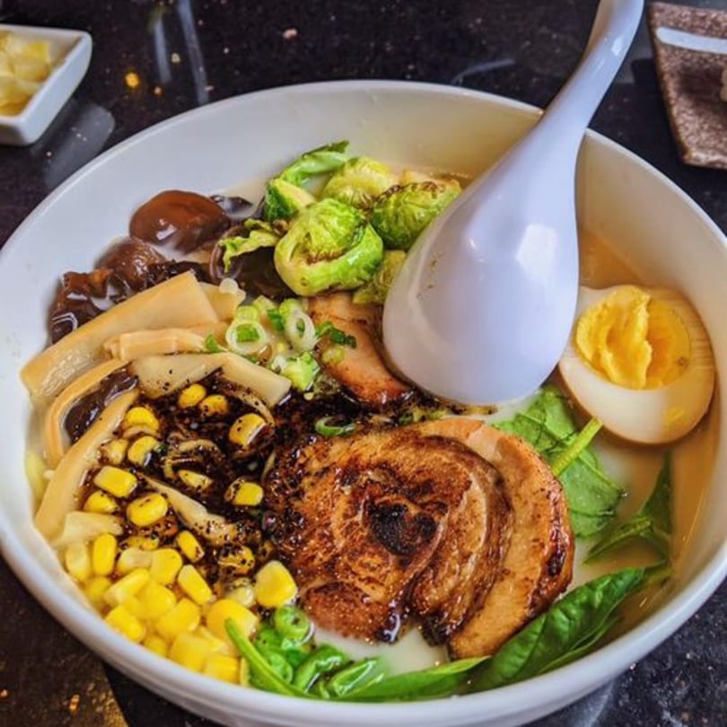 Fuumi ramen bowl with pork, corn, brussels sprouts, egg, and mushrooms in broth.